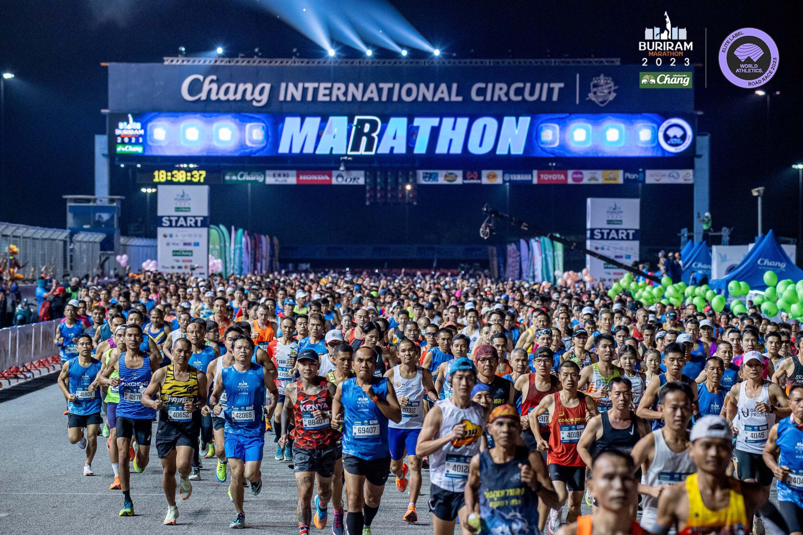 คู่มือ Buriram Marathon 2027: เวลาปล่อยตัว เส้นทาง และเวลาติด Top 10 คนไทย นักวิ่งมาราธอนออกจากซุ้มปล่อยตัวสนามช้าง อินเตอร์เนชั่นแนล เซอร์กิต ตอนกลางคืน Buriram Marathon 2023 ภาพของผู้จัด